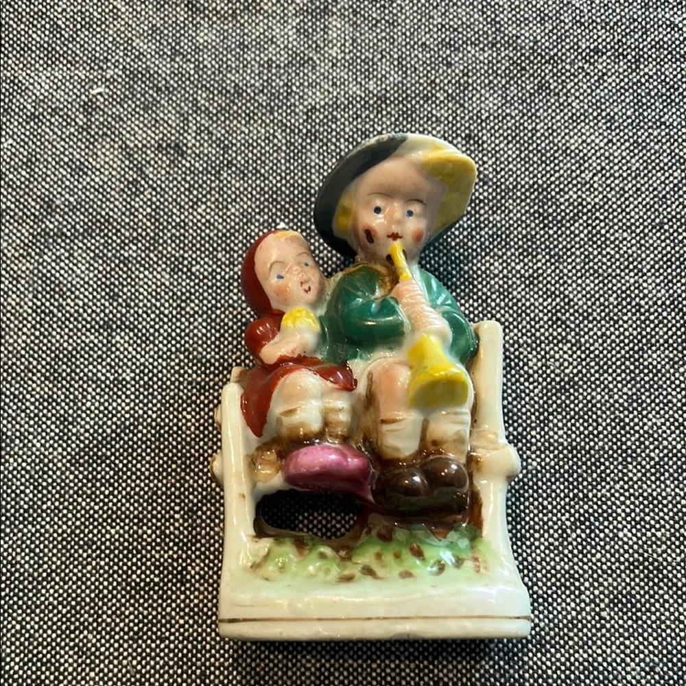 Porcelain Girl and Boy sitting on a bench playing a horn-occupied Japan